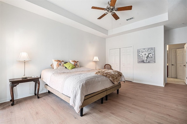21007 Sunpoint Way Unit 203, Lutz, FL 33558 - bedroom with a tray ceiling, light wood-type flooring, baseboards, and a closet