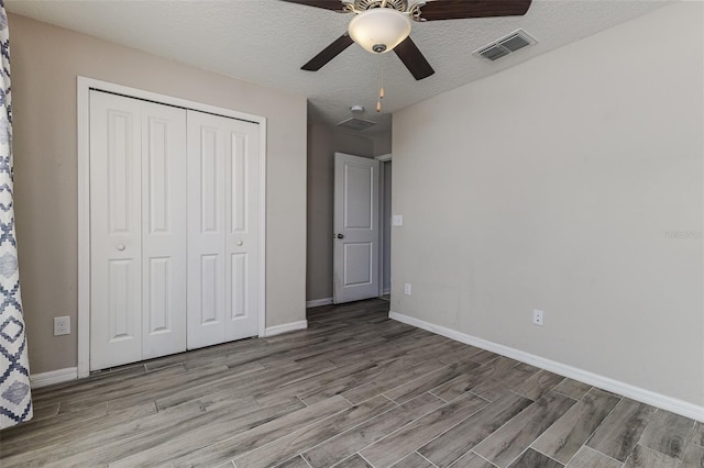 8812 Parsons Hill Blvd, Wesley Chapel, FL 33545 - unfurnished bedroom featuring light wood finished floors, a closet, baseboards, a ceiling fan, and a textured ceiling