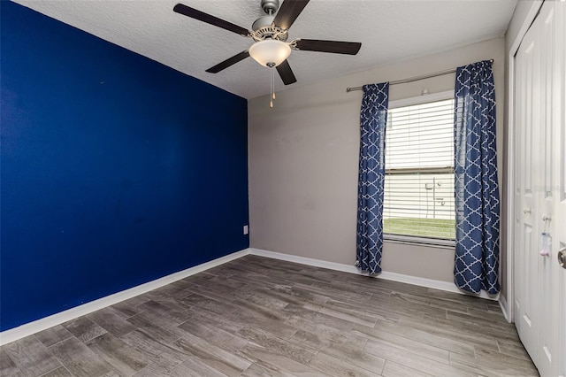 8812 Parsons Hill Blvd, Wesley Chapel, FL 33545 - spare room featuring healthy amount of natural light, wood finished floors, a textured ceiling, ceiling fan, and baseboards