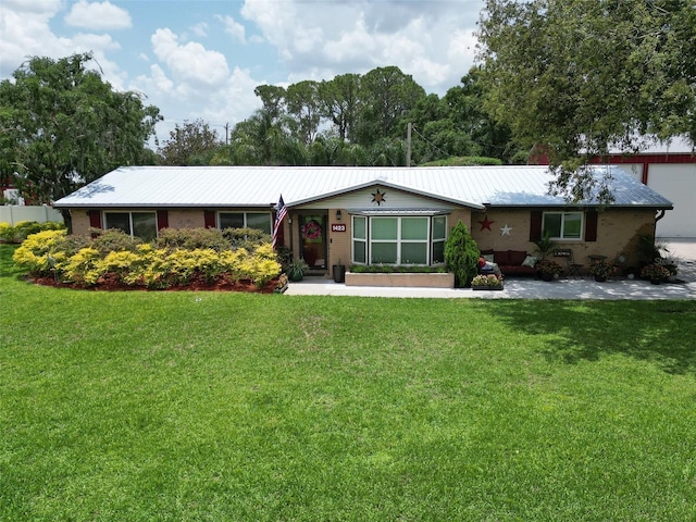 1423 Spruce Rd N, Lakeland, FL 33809 - ranch-style home with a front lawn and metal roof