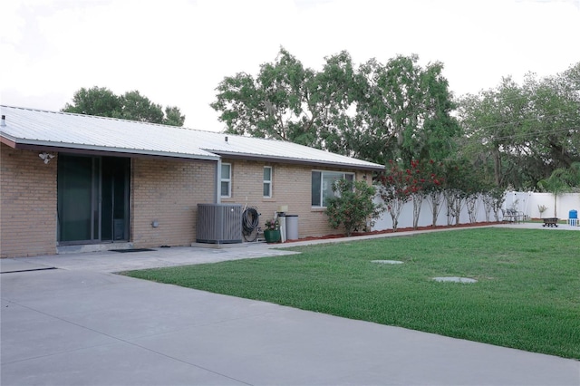1423 Spruce Rd N, Lakeland, FL 33809 - back of house featuring central AC unit, a patio area, and brick siding