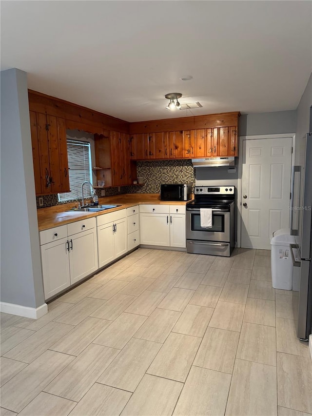 6345 Lambert Ln, New Port Richey, FL 34652 - kitchen with stainless steel electric stove, refrigerator, a sink, black microwave, and under cabinet range hood