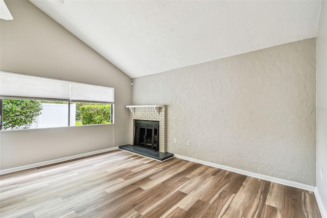 13501 Palmwood Ln Unit 0, Tampa, FL 33618 - unfurnished living room featuring lofted ceiling, wood finished floors, a fireplace, baseboards, and a textured wall