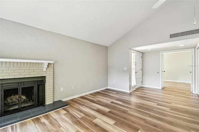 13501 Palmwood Ln Unit 0, Tampa, FL 33618 - unfurnished living room featuring wood finished floors, a fireplace, baseboards, and high vaulted ceiling