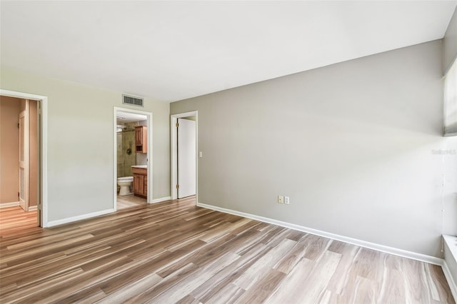 13501 Palmwood Ln Unit 0, Tampa, FL 33618 - unfurnished bedroom with baseboards, light wood finished floors, and ensuite bath