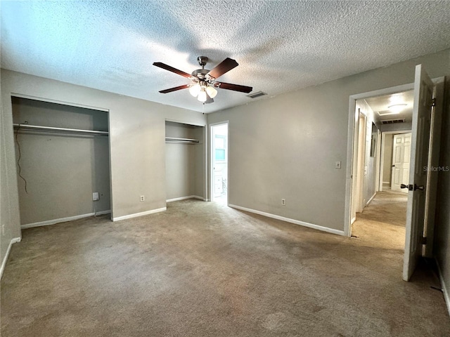 3419 Pearson Rd, Valrico, FL 33596 - unfurnished bedroom with two closets, baseboards, carpet flooring, a ceiling fan, and a textured ceiling