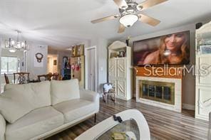 7523 Pitch Pine Cir Unit 184, Tampa, FL 33617 - living room featuring a glass covered fireplace, wood finished floors, a chandelier, a ceiling fan, and baseboards