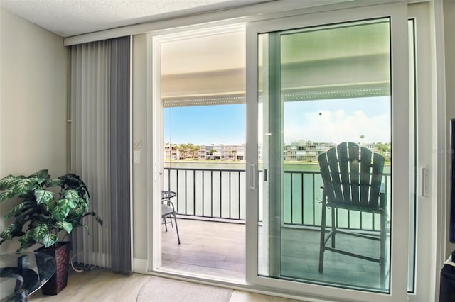 7625 Sun Island Dr S Unit 304, South Pasadena, FL 33707 - doorway to outside with wood finished floors, a water view, and a textured ceiling