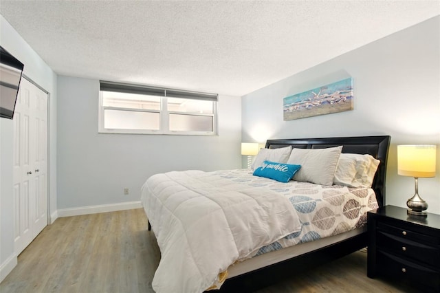 7625 Sun Island Dr S Unit 304, South Pasadena, FL 33707 - bedroom featuring wood finished floors, a textured ceiling, and a closet