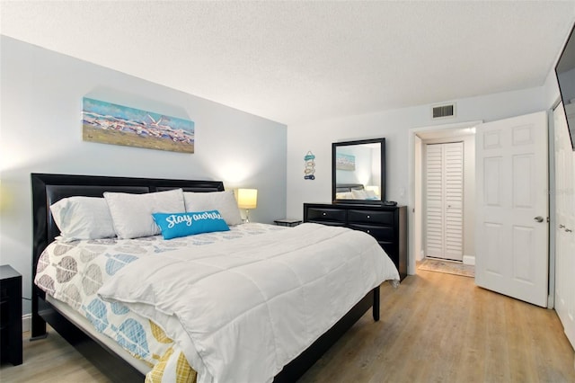 7625 Sun Island Dr S Unit 304, South Pasadena, FL 33707 - bedroom with light wood-style floors and a textured ceiling