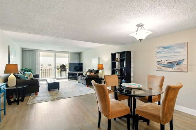 7625 Sun Island Dr S Unit 304, South Pasadena, FL 33707 - dining room featuring a textured ceiling and light wood finished floors