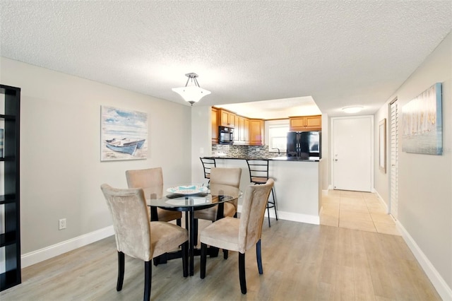 7625 Sun Island Dr S Unit 304, South Pasadena, FL 33707 - dining room featuring light wood-style floors and a textured ceiling
