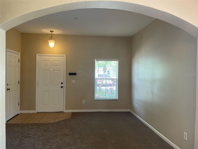 10303 Park Commons Dr, Orlando, FL 32832 - carpeted foyer entrance with arched walkways, tile patterned floors, and baseboards