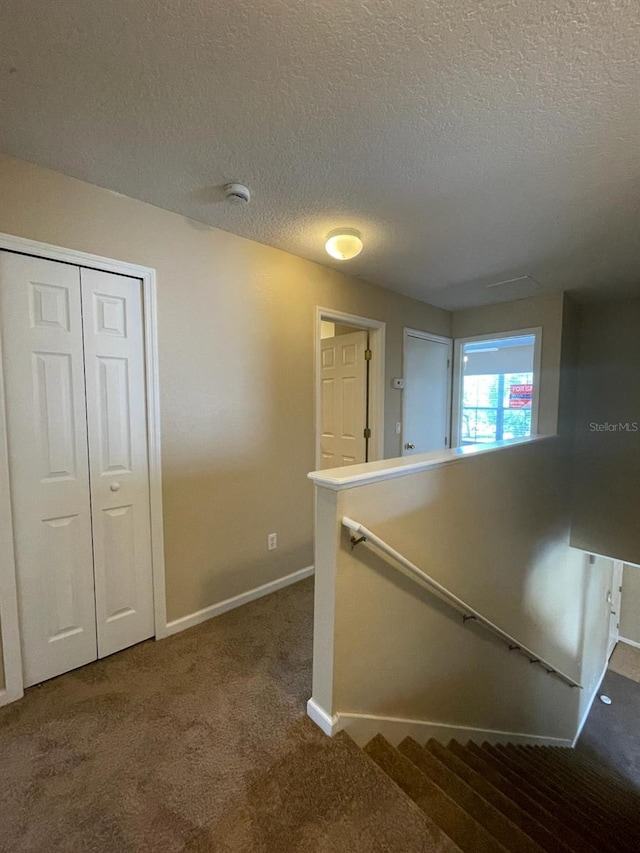 10303 Park Commons Dr, Orlando, FL 32832 - hallway with an upstairs landing, carpet floors, baseboards, and a textured ceiling