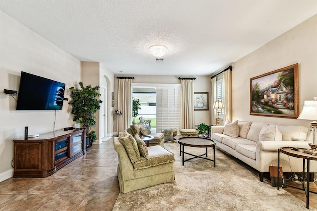3302 Granite Ridge Loop, Land O Lakes, FL 34638 - tiled living area featuring plenty of natural light, baseboards, and a textured ceiling