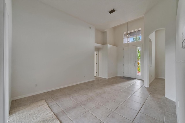 2803 Abbey Grove Dr, Valrico, FL 33594 - foyer featuring light tile patterned floors, a high ceiling, baseboards, a chandelier, and arched walkways