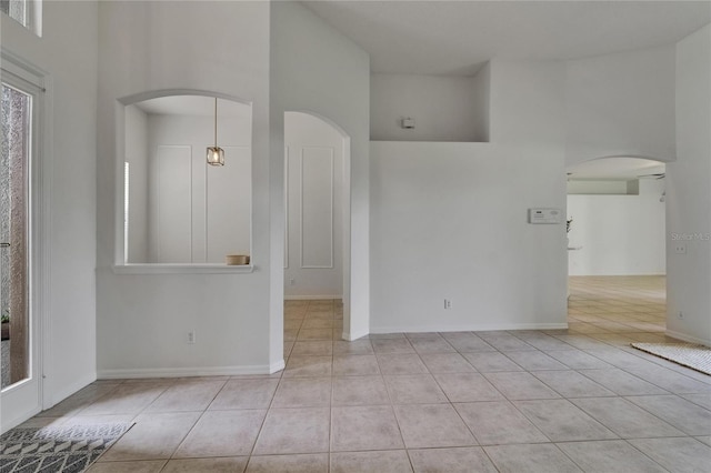 2803 Abbey Grove Dr, Valrico, FL 33594 - tiled empty room with arched walkways, a high ceiling, and baseboards