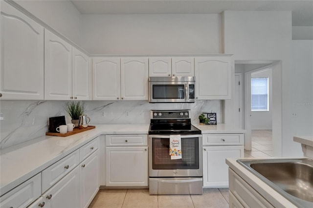 2803 Abbey Grove Dr, Valrico, FL 33594 - kitchen with stainless steel appliances, light tile patterned floors, tasteful backsplash, and white cabinetry