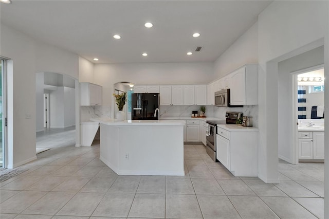 2803 Abbey Grove Dr, Valrico, FL 33594 - kitchen featuring appliances with stainless steel finishes, arched walkways, light tile patterned floors, and recessed lighting
