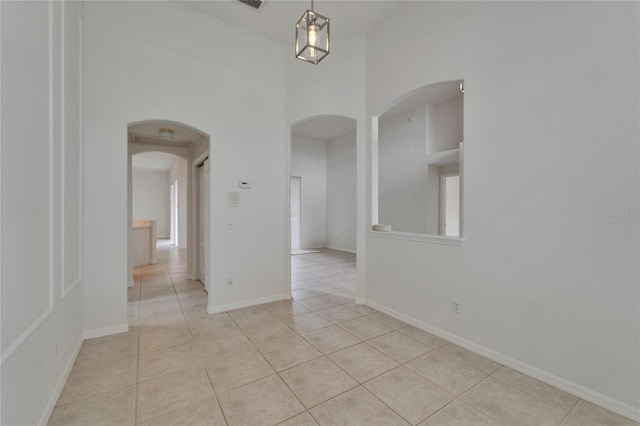 2803 Abbey Grove Dr, Valrico, FL 33594 - empty room with arched walkways, light tile patterned floors, and baseboards