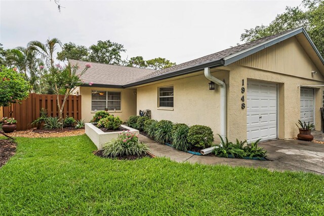 1948 Elaine Dr, Clearwater, FL 33760 - view of front facade with driveway, stucco siding, a garage, and a shingled roof