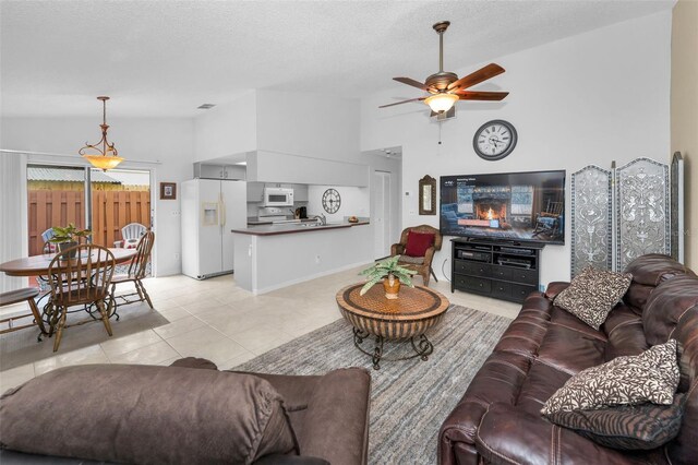 1948 Elaine Dr, Clearwater, FL 33760 - living area featuring a ceiling fan, light tile patterned floors, high vaulted ceiling, and a textured ceiling