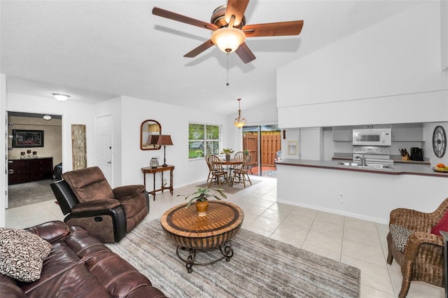 1948 Elaine Dr, Clearwater, FL 33760 - living room with light tile patterned floors, ceiling fan, baseboards, and vaulted ceiling