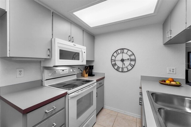 1948 Elaine Dr, Clearwater, FL 33760 - kitchen featuring white appliances, gray cabinets, baseboards, light tile patterned floors, and light countertops