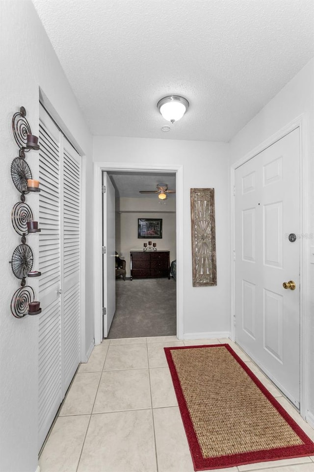 1948 Elaine Dr, Clearwater, FL 33760 - hall with light carpet, a textured ceiling, light tile patterned floors, and baseboards