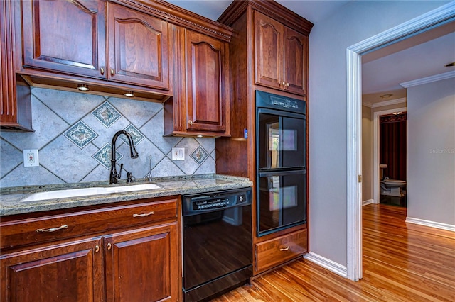 13635 Twin Lakes Ln Unit 13635, Tampa, FL 33618 - kitchen featuring black appliances, a sink, light wood-style floors, tasteful backsplash, and crown molding