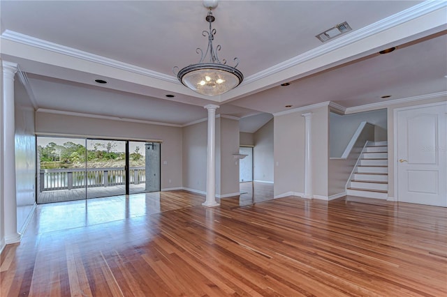 13635 Twin Lakes Ln Unit 13635, Tampa, FL 33618 - unfurnished living room featuring decorative columns, wood finished floors, baseboards, stairs, and ornamental molding