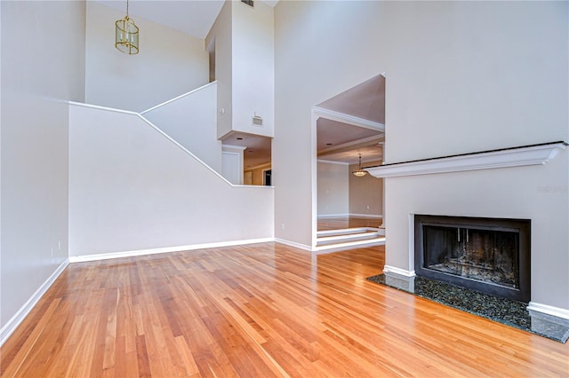 13635 Twin Lakes Ln Unit 13635, Tampa, FL 33618 - unfurnished living room with wood finished floors, a high ceiling, a fireplace with flush hearth, baseboards, and stairs