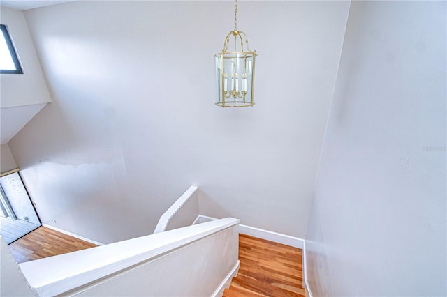 13635 Twin Lakes Ln Unit 13635, Tampa, FL 33618 - staircase featuring wood finished floors, baseboards, and a chandelier