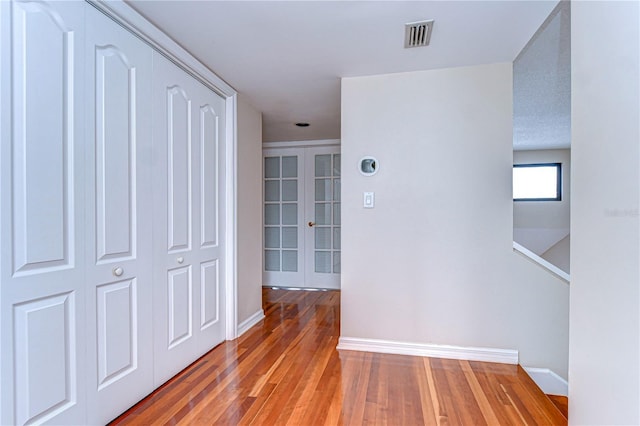 13635 Twin Lakes Ln Unit 13635, Tampa, FL 33618 - hallway featuring light wood-type flooring, baseboards, and french doors