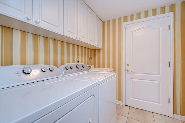 13635 Twin Lakes Ln Unit 13635, Tampa, FL 33618 - laundry room featuring washer and dryer, cabinet space, light tile patterned floors, wallpapered walls, and baseboards