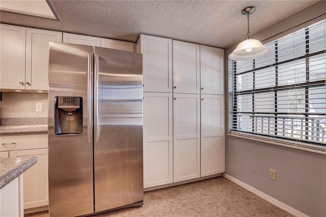 11800 Park Blvd Unit 208, Seminole, FL 33772 - kitchen featuring stainless steel fridge, white cabinets, light countertops, a textured ceiling, and pendant lighting