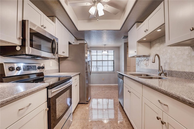 11800 Park Blvd Unit 208, Seminole, FL 33772 - kitchen with stainless steel appliances, a tray ceiling, ceiling fan, decorative backsplash, and white cabinets