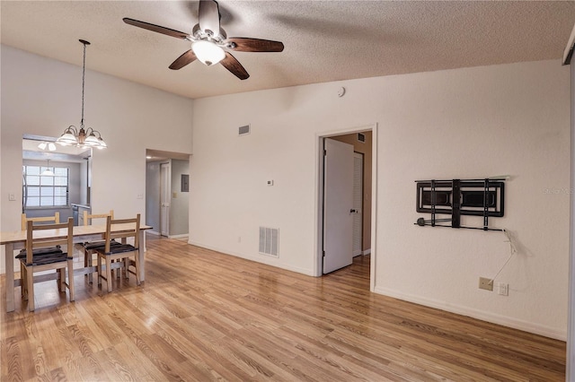 11800 Park Blvd Unit 208, Seminole, FL 33772 - dining area featuring lofted ceiling, a ceiling fan, a chandelier, light wood finished floors, and a textured ceiling