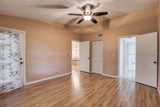 11800 Park Blvd Unit 208, Seminole, FL 33772 - unfurnished bedroom with light wood-style flooring, a textured ceiling, ensuite bathroom, ceiling fan, and a closet