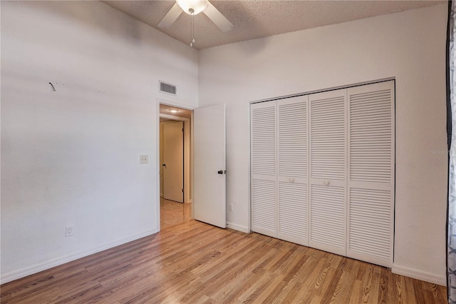 11800 Park Blvd Unit 208, Seminole, FL 33772 - unfurnished bedroom featuring light wood-style floors, a closet, a ceiling fan, and a textured ceiling