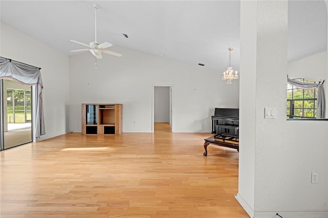 206 Forest Wood Ct, Spring Hill, FL 34609 - unfurnished living room featuring high vaulted ceiling, a ceiling fan, a chandelier, light wood-style flooring, and a wood stove