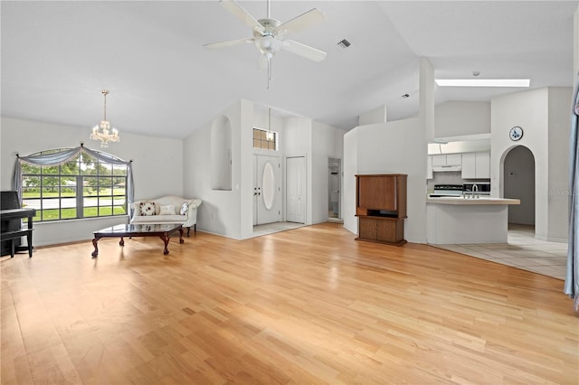 206 Forest Wood Ct, Spring Hill, FL 34609 - living room with high vaulted ceiling, ceiling fan, light wood-style floors, a chandelier, and arched walkways