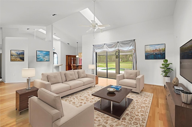 206 Forest Wood Ct, Spring Hill, FL 34609 - living area featuring light wood finished floors, ceiling fan, high vaulted ceiling, and a skylight