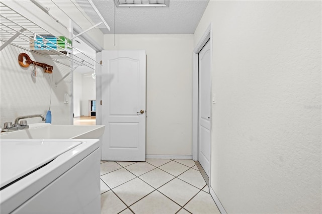 206 Forest Wood Ct, Spring Hill, FL 34609 - laundry area with washer / dryer, light tile patterned floors, a textured ceiling, and baseboards
