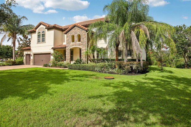 19711 Wellington Manor Blvd, Lutz, FL 33549 - mediterranean / spanish-style home featuring a garage, stone siding, stucco siding, a tile roof, and a front lawn