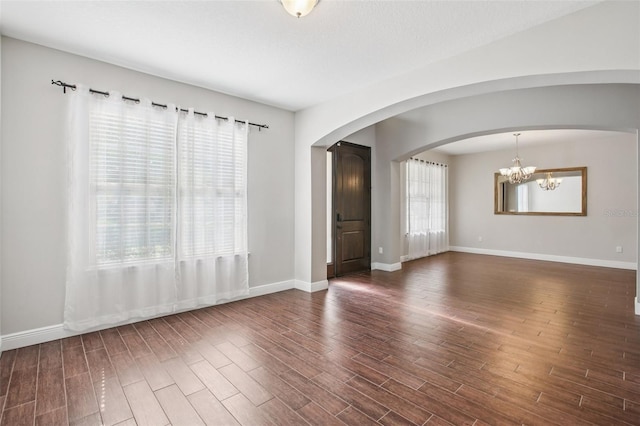 19711 Wellington Manor Blvd, Lutz, FL 33549 - empty room featuring wood finished floors, arched walkways, and a chandelier