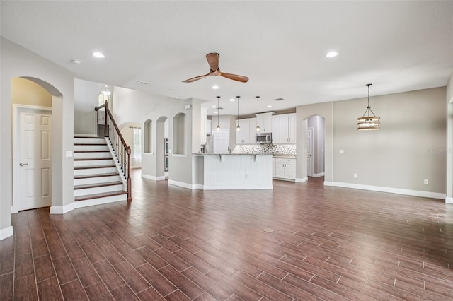 19711 Wellington Manor Blvd, Lutz, FL 33549 - unfurnished living room with ceiling fan, dark wood finished floors, recessed lighting, stairway, and arched walkways