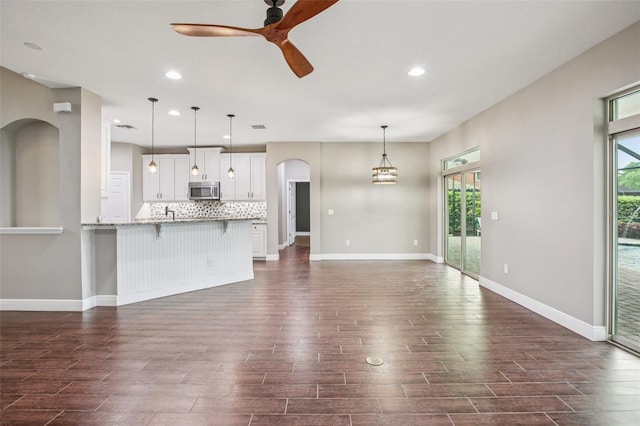 19711 Wellington Manor Blvd, Lutz, FL 33549 - unfurnished living room with dark wood-style flooring, ceiling fan, plenty of natural light, and recessed lighting