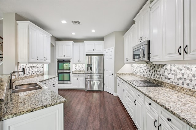 19711 Wellington Manor Blvd, Lutz, FL 33549 - kitchen with stainless steel appliances, dark wood finished floors, white cabinets, decorative backsplash, and recessed lighting