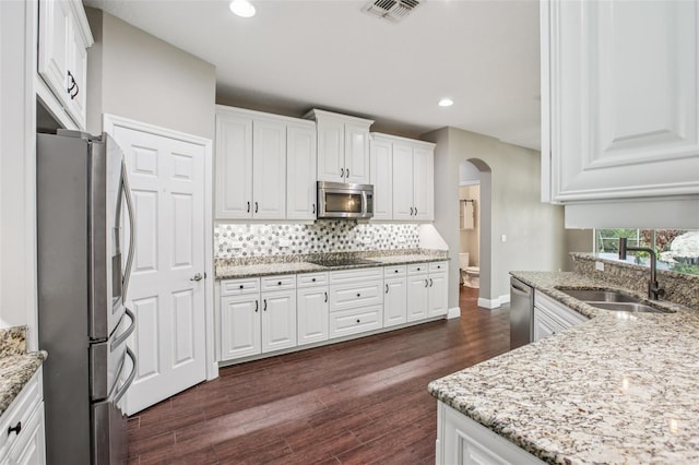 19711 Wellington Manor Blvd, Lutz, FL 33549 - kitchen featuring stainless steel appliances, arched walkways, white cabinetry, backsplash, and recessed lighting